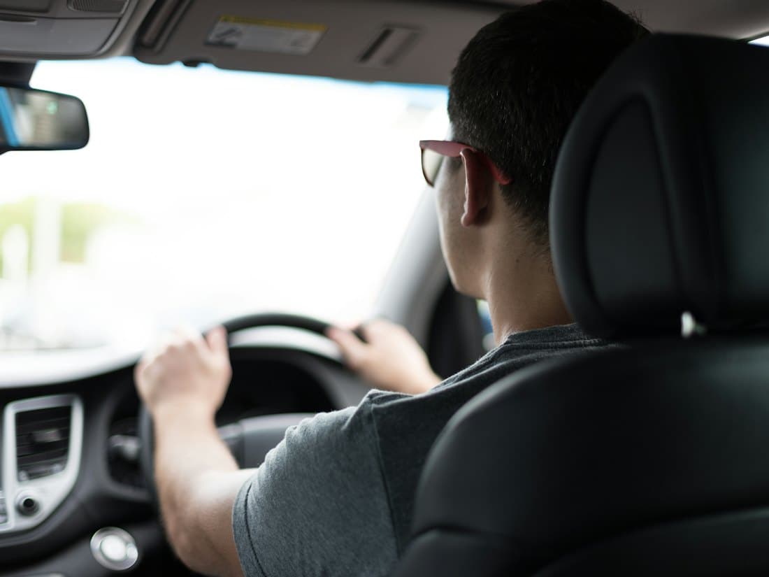 A learner driver at the wheel during a daytime lesson